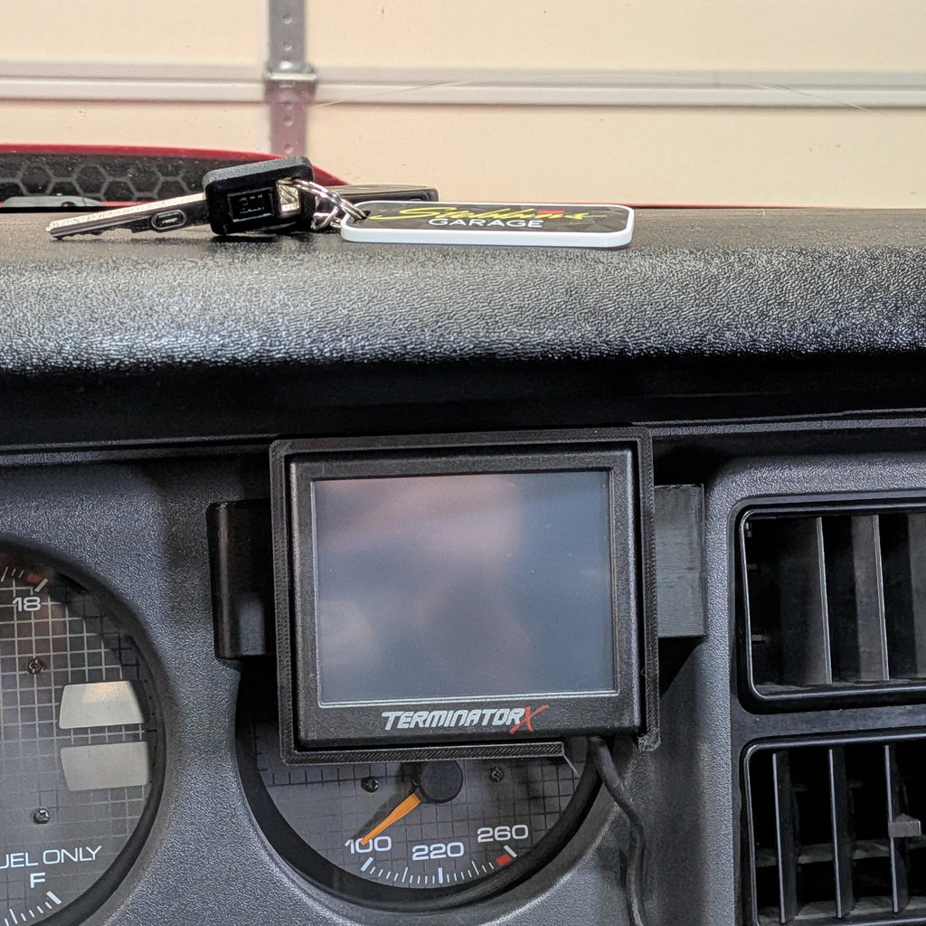 Car dashboard with a digital display and keychain on a beige background