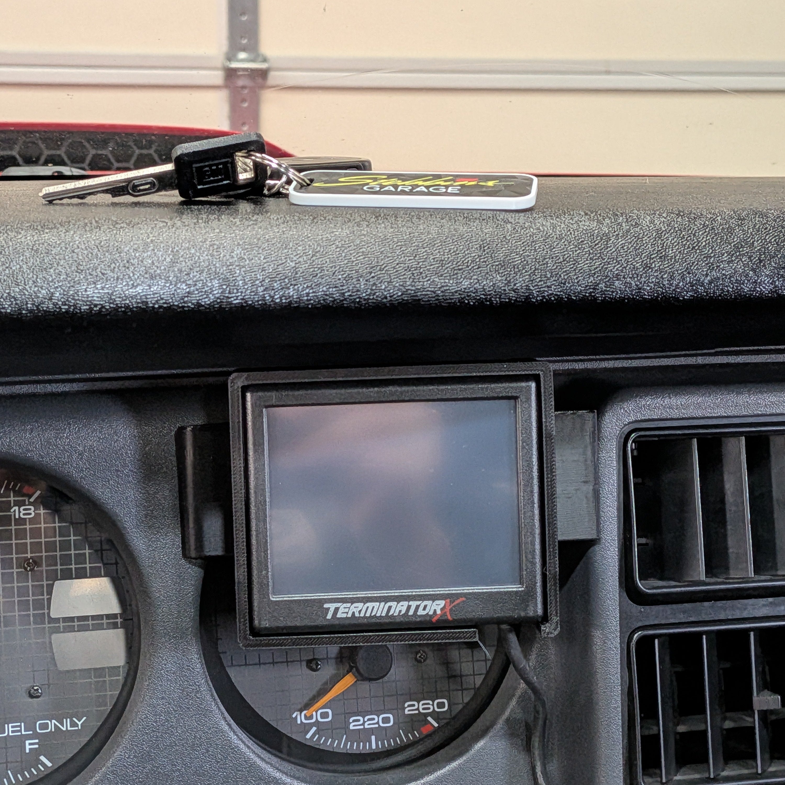 Car dashboard with a digital display and keychain on a beige background